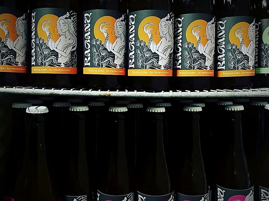 Amatininkų gėrimų buteliai su iliustruotomis etiketėmis tamsioje lentynoje